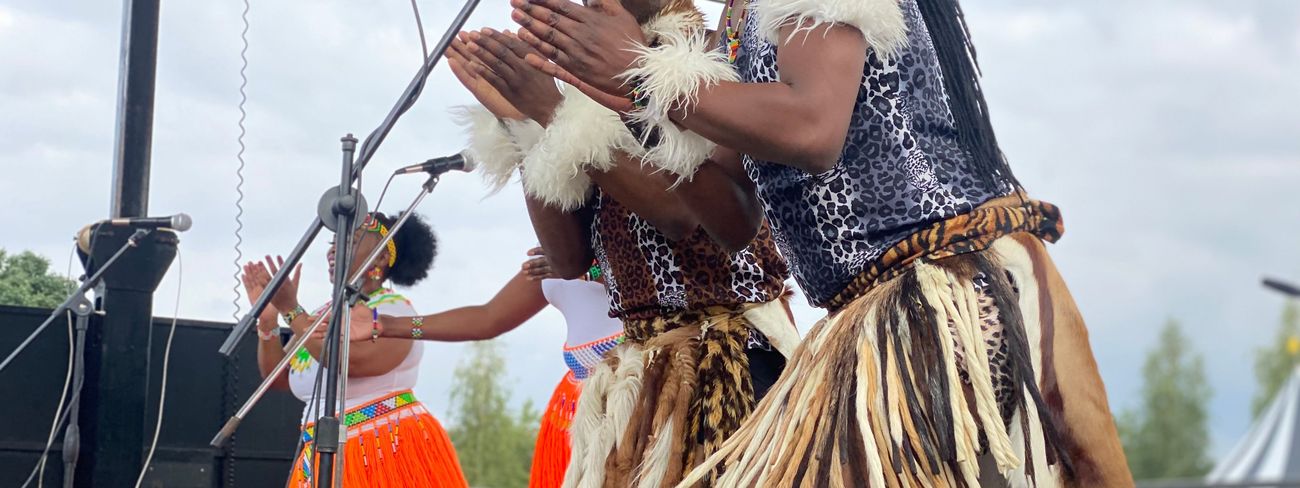 Dancers celebrating on an outdoor festival stage
