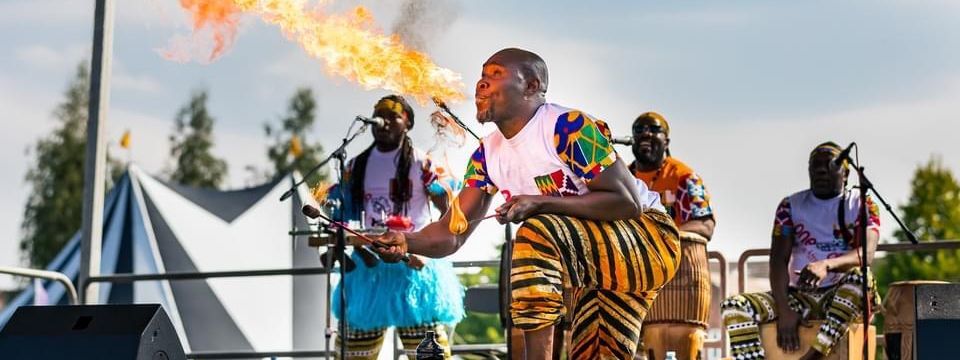 Fire breather performing on stage at an outdoor event