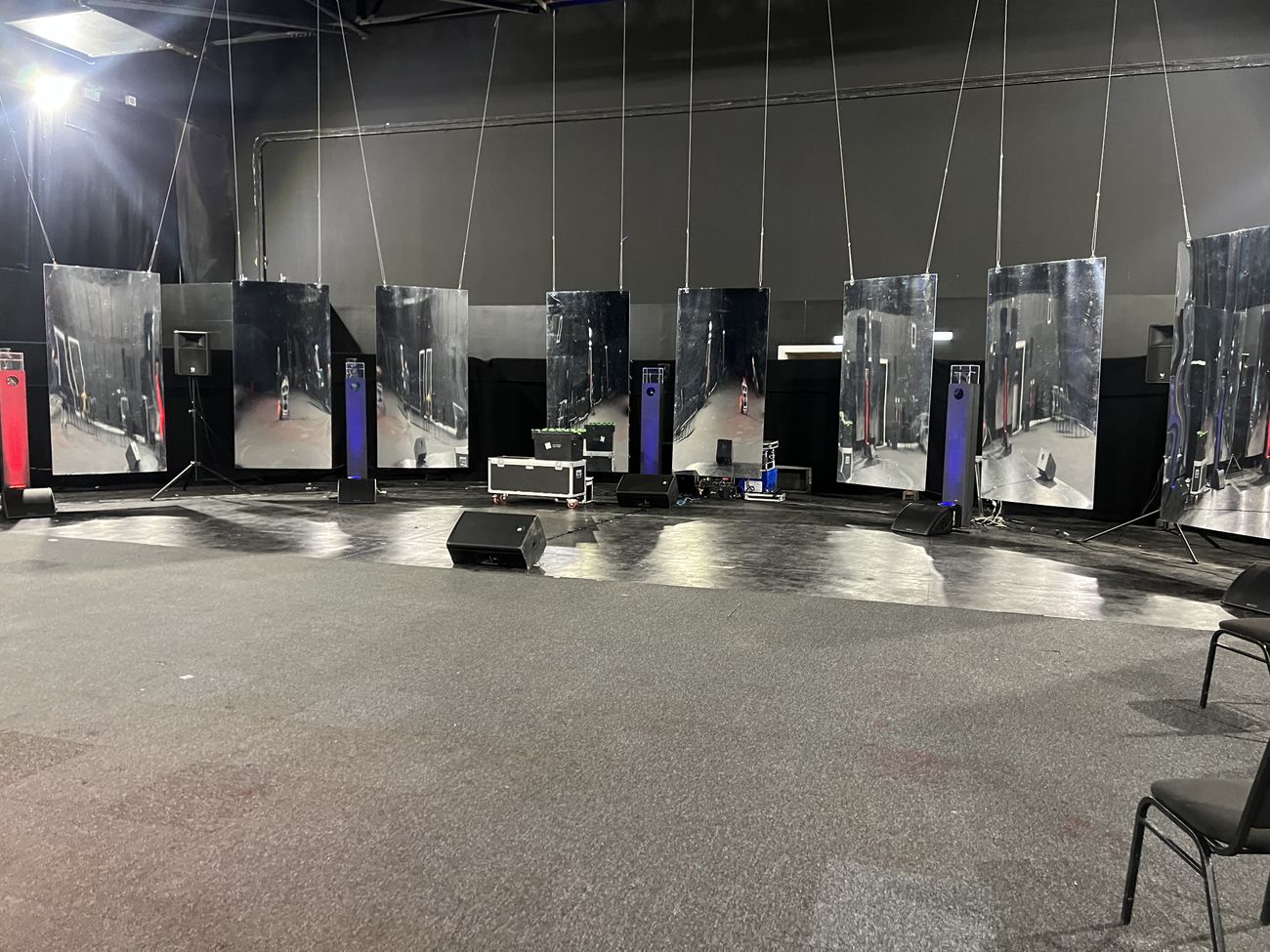 Indoor venue stage with suspended mirror panels and lighting