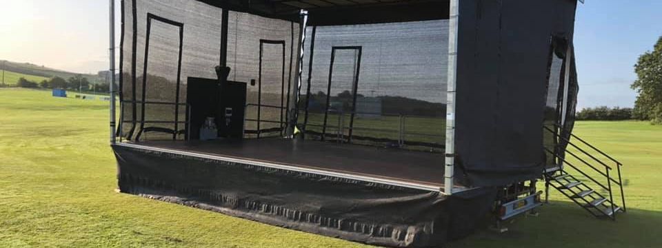 Mobile trailer stage set up on a field for a fundraising event